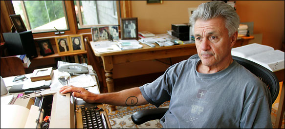 Author John Irving poses at his desk