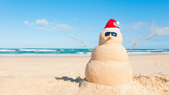 Snowman made of sand wearing sunglasses on the beach
